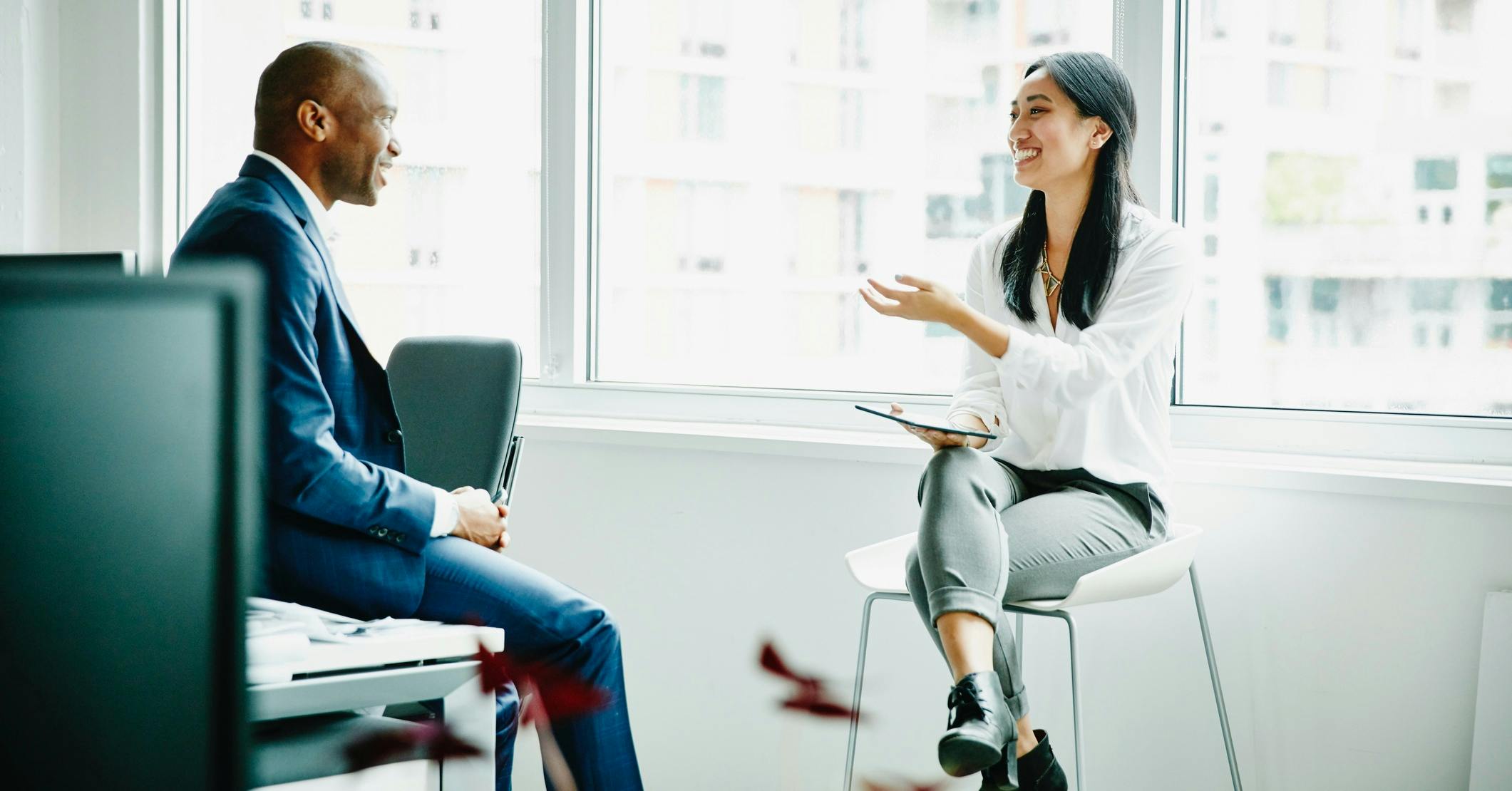 Business man and woman having meeting at workstation