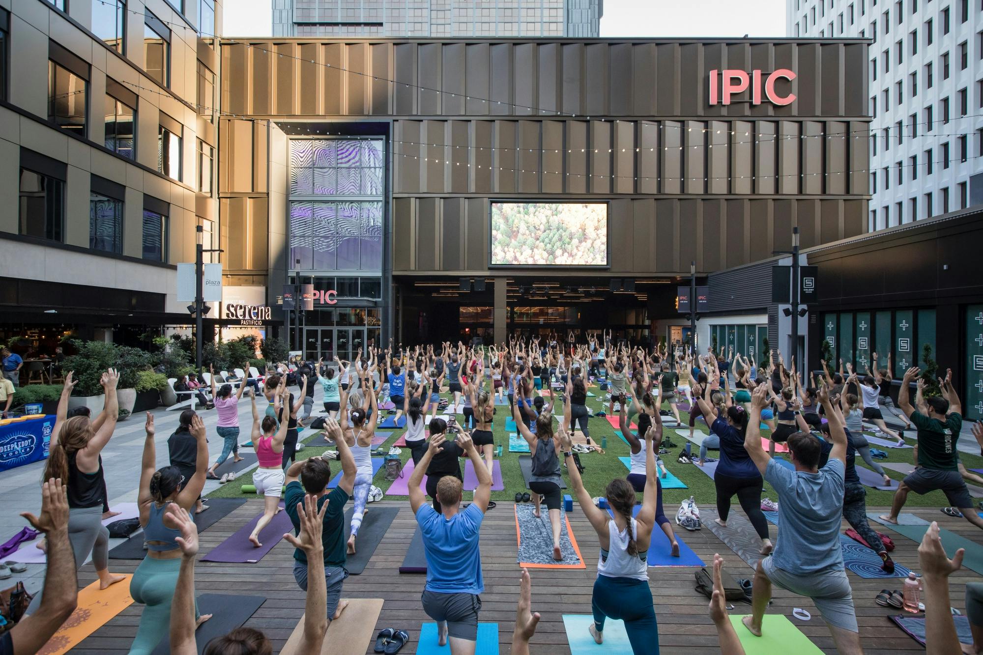 Crowd yoga in plaza outside Colony Square