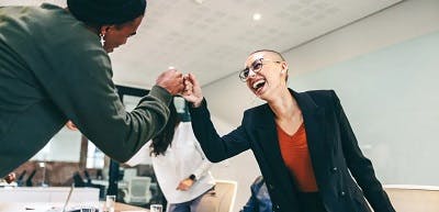 two women fist bumping