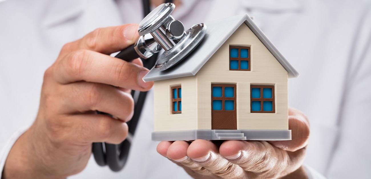 Doctor examining house model with stethoscope