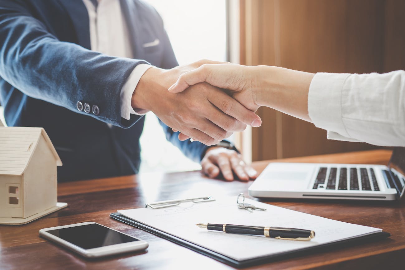 Close Up of an Agent and Client Shaking Hands Over the Close of a Home Sale or Purchase Transaction