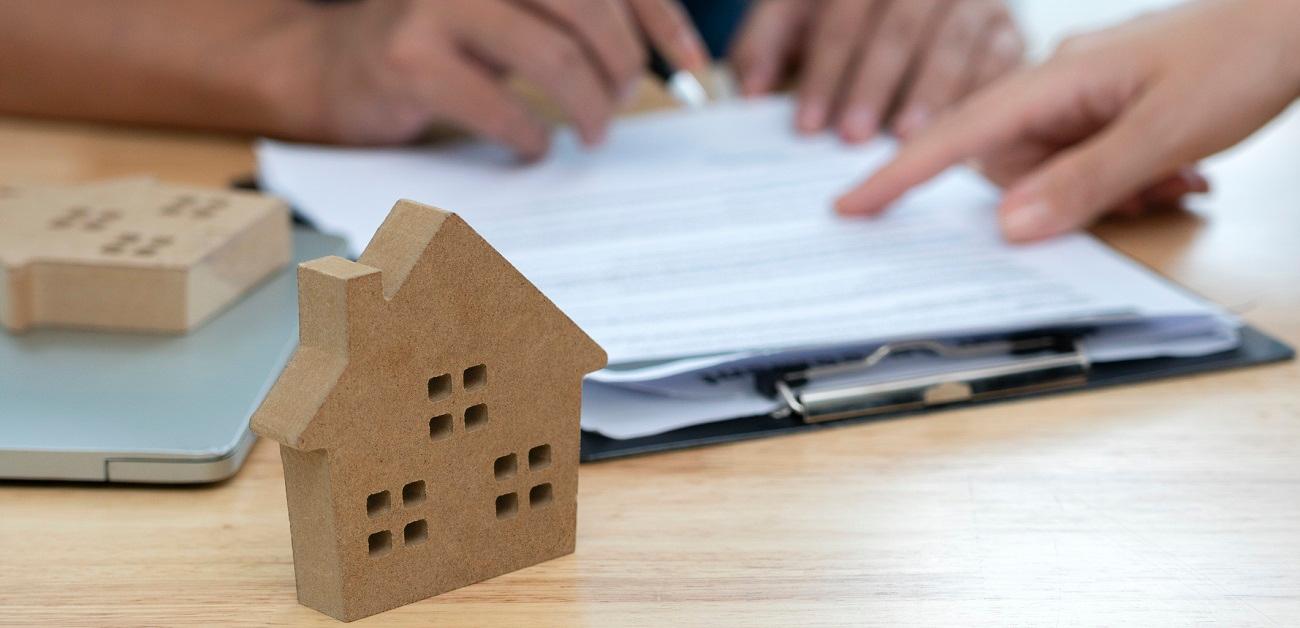 House model with people signing paperwork