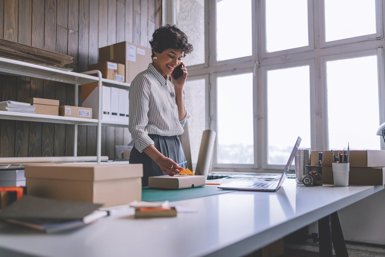 Woman Conducting Business - Working on Laptop, Writing Post-It, Talking on Cell Phone