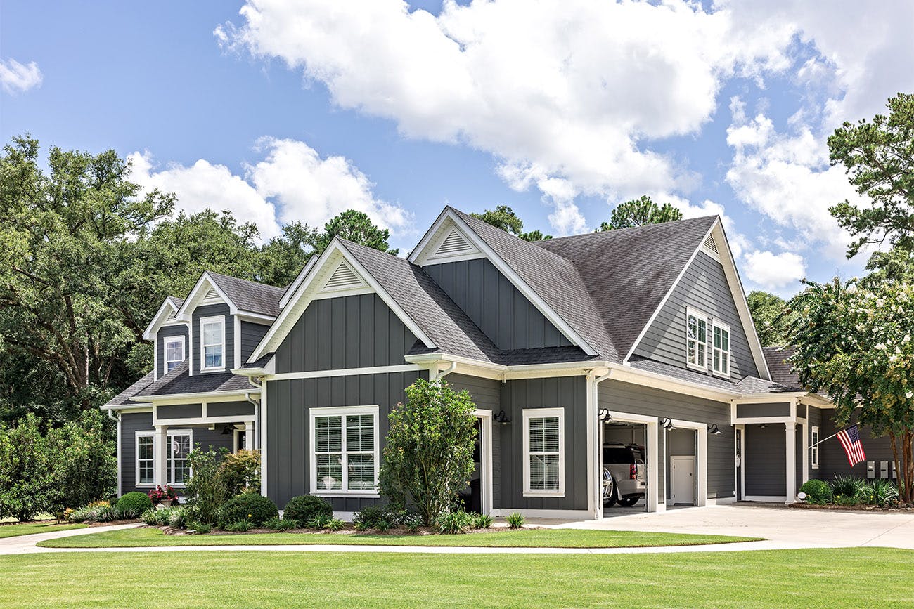 Large dark gray house with lawn