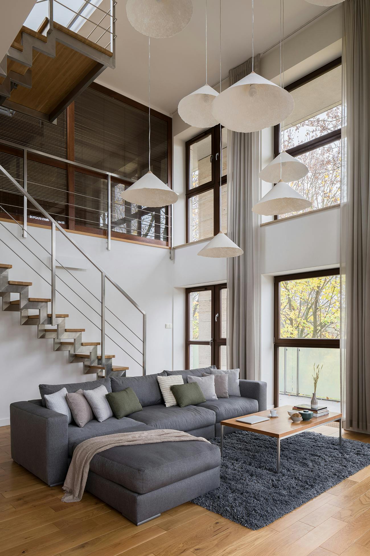 Living room with cathedral ceilings and stairway to upper floor