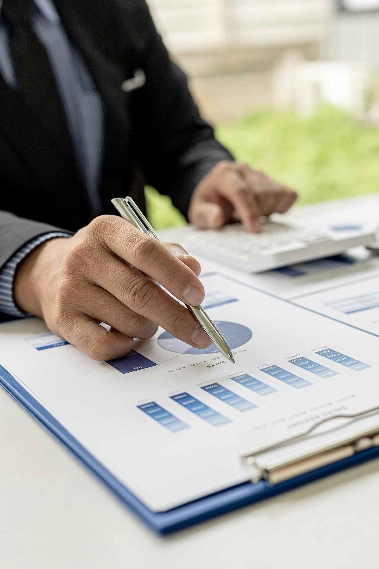 Man in a suit reviewing graphs