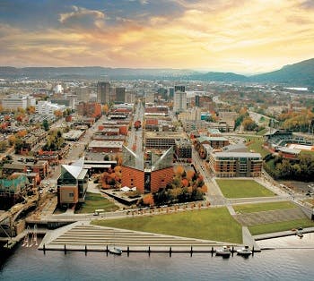 Aerial view of Chattanooga showing a park near the water and mountains in the background