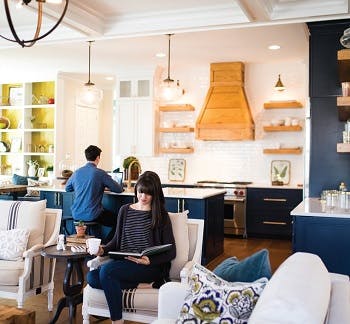 Multipurpose room showing a kitchen in the background and a living room in the foreground