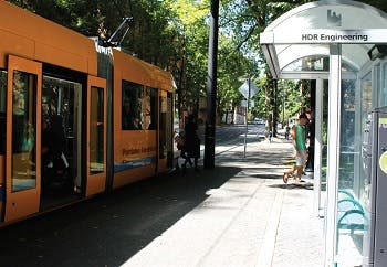 An orange street car at a stop in Portland, OR