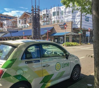 An electric car parked from a company called Lime parked on the street 