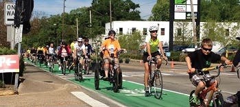 Several people riding their bicycles on a bike lane in an urban area