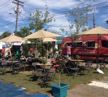 Patio tables and chairs set up with open umbrellas in an outdoor area