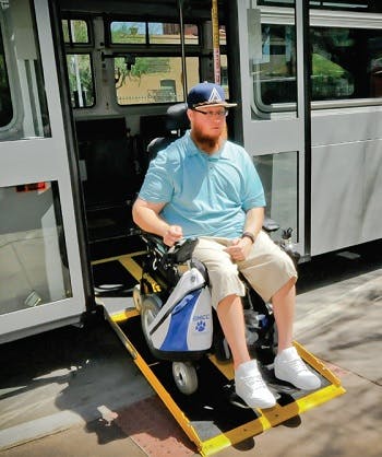 A man in a wheelchair exiting a bus