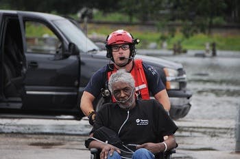 A paramedic helping a man in a wheelchair