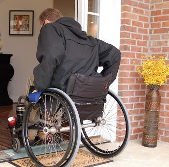 Man in wheelchair entering home