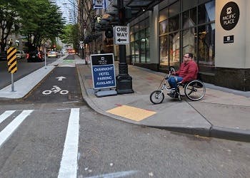 Man riding a handicap bicycle on an accessible sidewalk