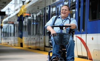 A person riding a handicap scooter in a lightrail station