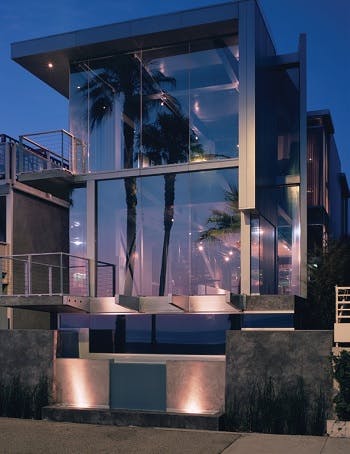 The glass facade of a two-level modern style home 