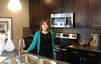 A woman standing next to a sink in a new kitchen