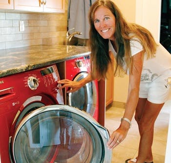 A woman standing next to a red washer and dryer