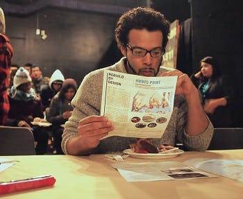 Man eating a meal and reading a brochure at a local workshop