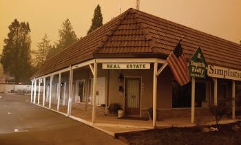 A shopping mall showing the entrance to a real estate office in Paradise, CA