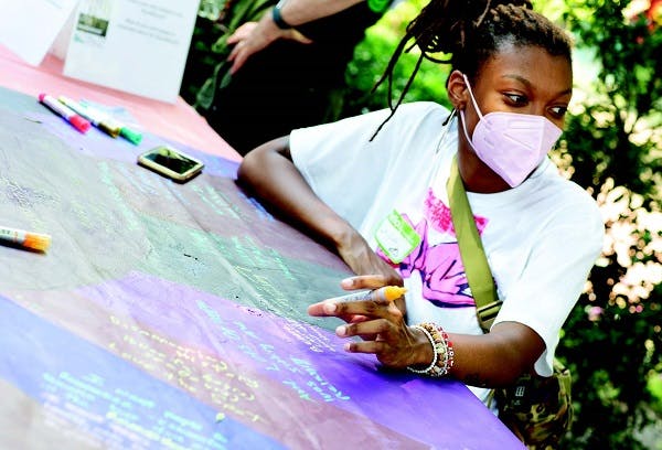 Black woman writing on a board using art-engagement tools