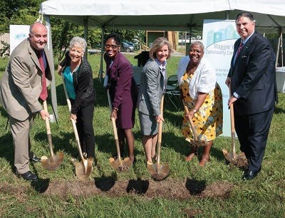 Businesspeople holding shovels at a Maggie Walker Community Land Trust event