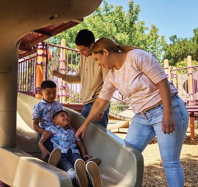 Couple watching kids in playground slide