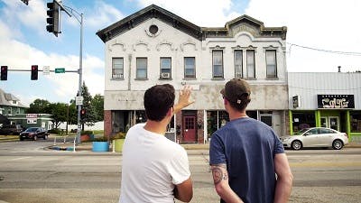 Two men looking at an old building facade