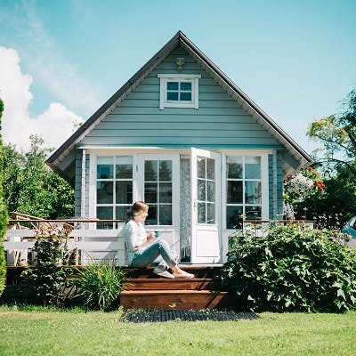 Woman sitting outdoors at a house deck