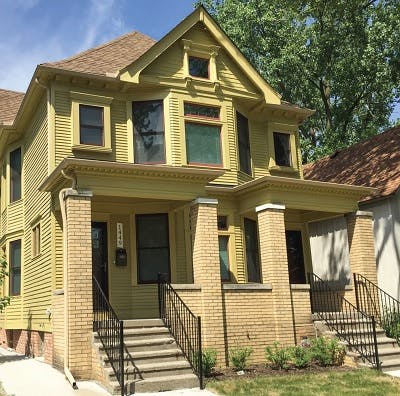 Front yard of a new two-story yellow home 