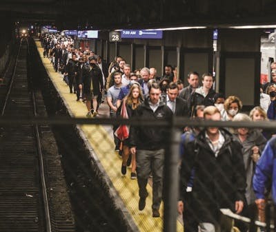 People walking on a busy subway station platform