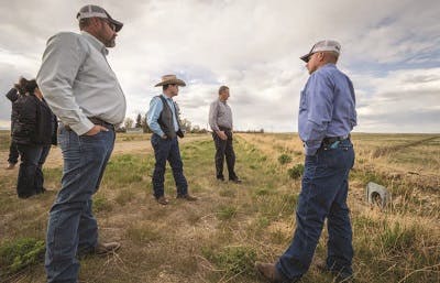 Farmers standing on empty field affected by drought 