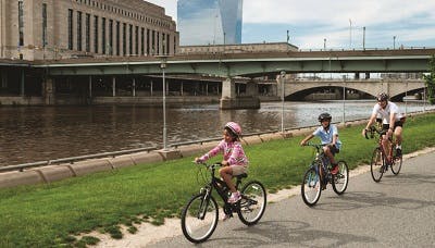 A parent biking with his kids along a river canal