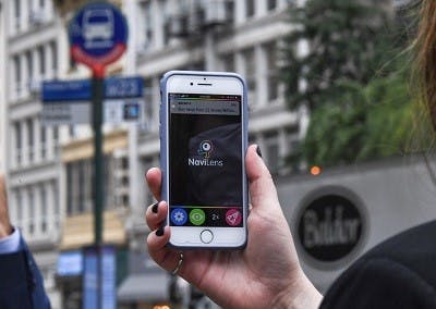 Woman's hand holding a smart phone on the street