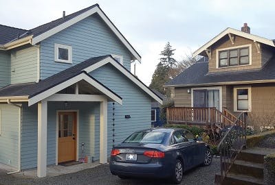 New home with blue siding showing a car parked in the driveway