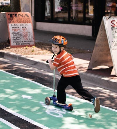 Boy riding scooter on bike lane