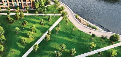 Aerial view of green area next to buildings and river