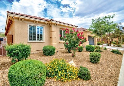 A house frontyard in Phoenix featuring xeriscaping, which uses native plants and desert vegetation, reduces water usage on lands