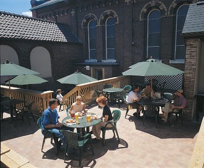 People sitting at tables drinking beer at the Church Brew Works Hop Gardens patio in Pittsburgh, PA