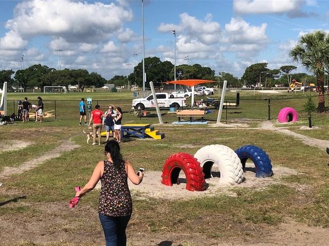 Melbourne, FL dog park - woman walking, people talking, painted tires, covered bench