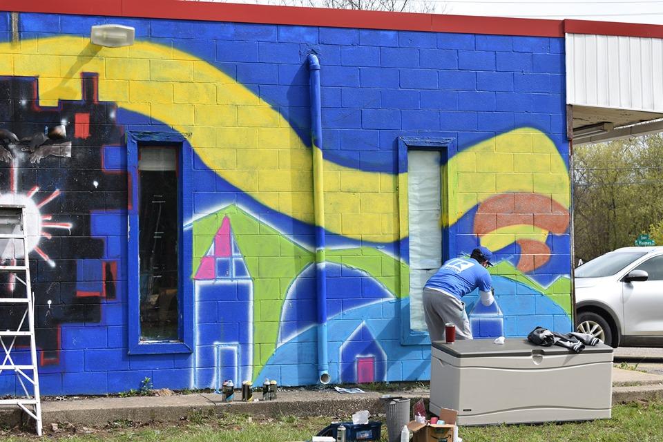 Lansing, MI, Pop-Up Park - REALTOR and talented artist Frank Vicente painting a mural on the back of the building