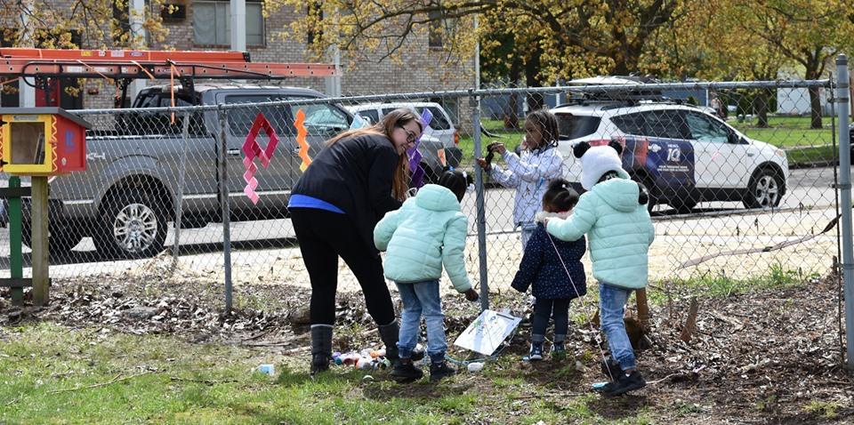 Lansing, MI, Pop-Up Park - a woman and 4 kids decorating a fence