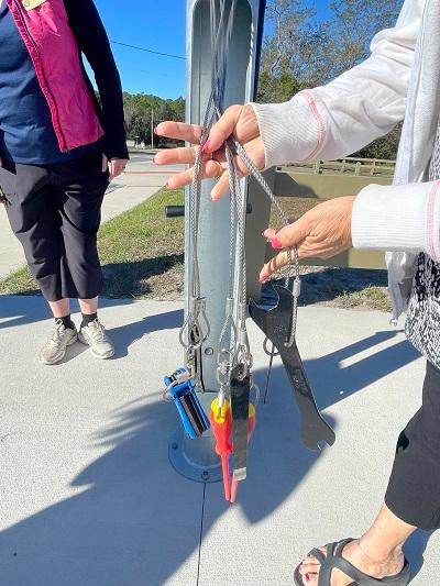 Woman showing the tools available at the bike repair station in DeBary, FL