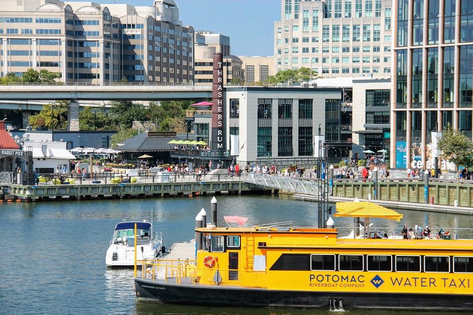 A view of The Wharf showing the Potomac Water Taxi boat and the boardwalk and restaurants in the background