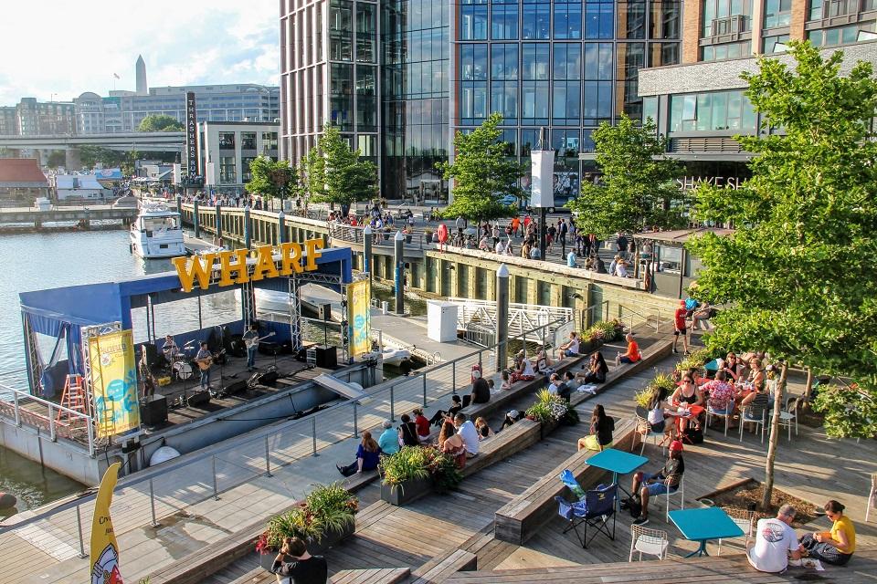 View of The Wharf showing a band playing on a floating stage by the water