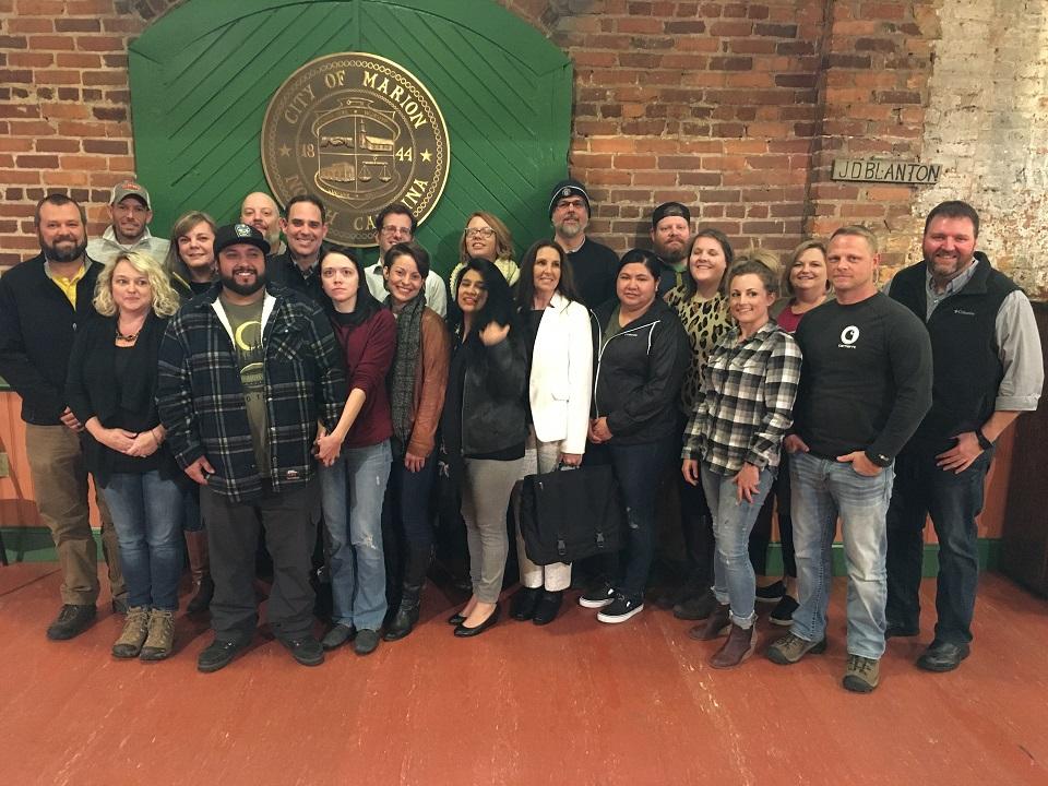 Group photo taken in front of a gate displaying the City of Marion emblem