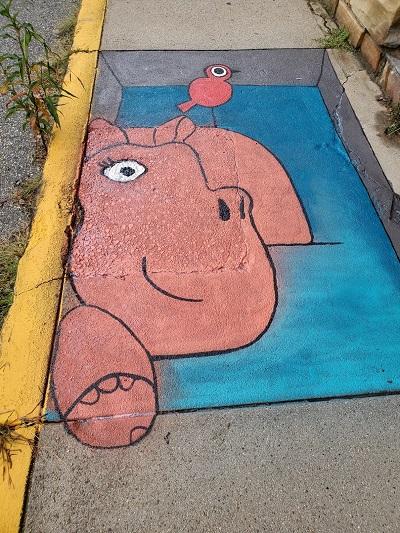 A 3D painting of hippo and bird pals covers up imperfections in the concrete.