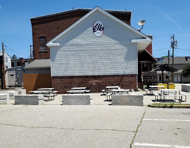 Parking lot (after image): Picnic tables and benches give community residents a place to enjoy a meal outdoors.